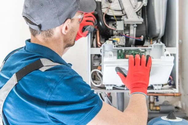 HVAC technician inspecting a furnace for repair or replacement in a GTA home