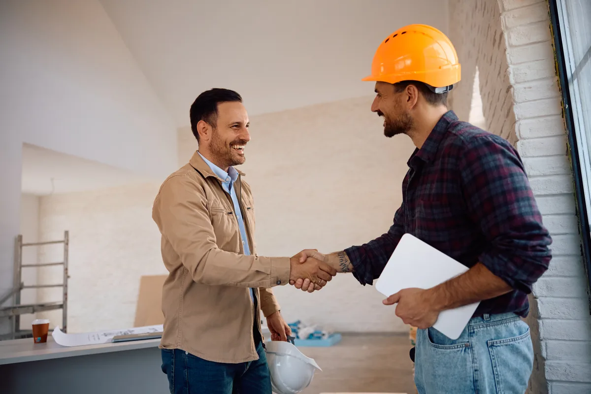 Homeowner shaking hands with a licensed HVAC contractor after reviewing a written quote