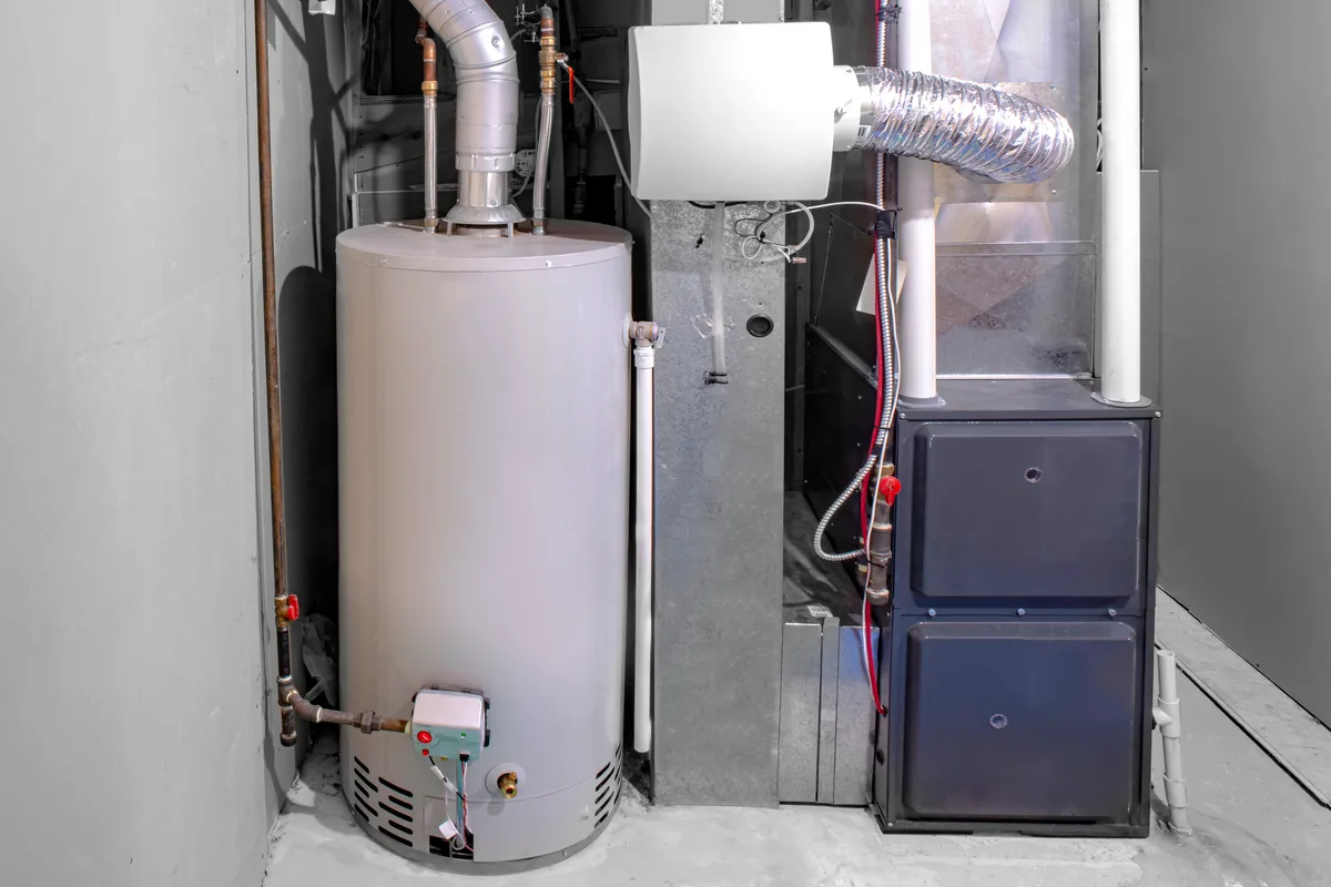 Residential gas tank water heater installed beside a high-efficiency furnace in a GTA home