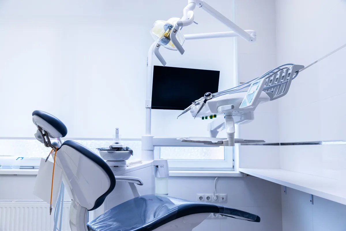 Empty dental operatory with treatment chair, overhead light and ceiling air vents