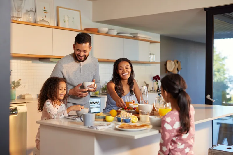 Family enjoying breakfast in a bright cool kitchen