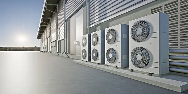 Industrial HVAC condenser units on commercial warehouse wall