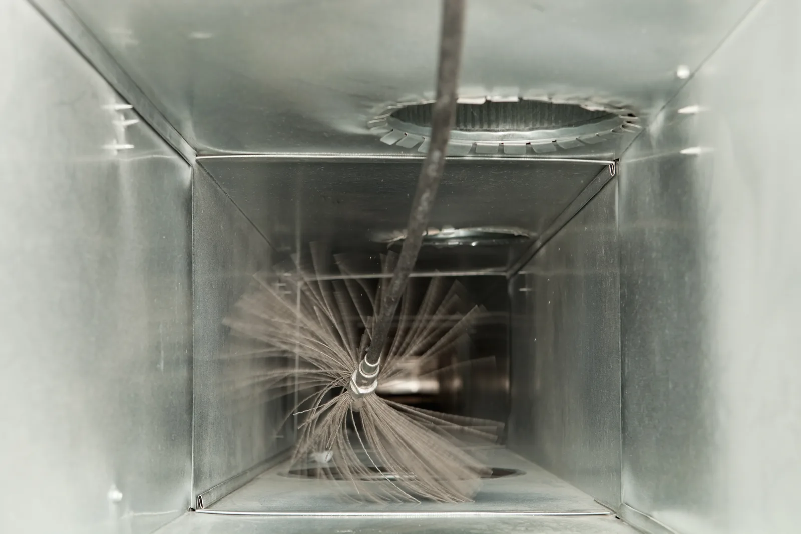 Rotary brush cleaning the inside of a residential air duct