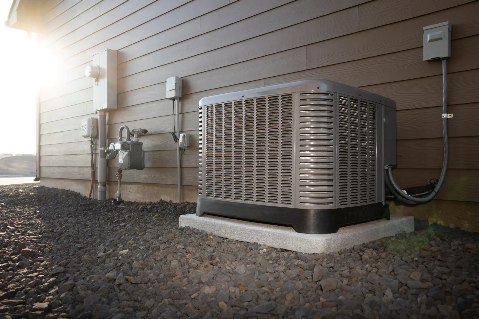 Central air conditioner condenser unit installed beside a home exterior