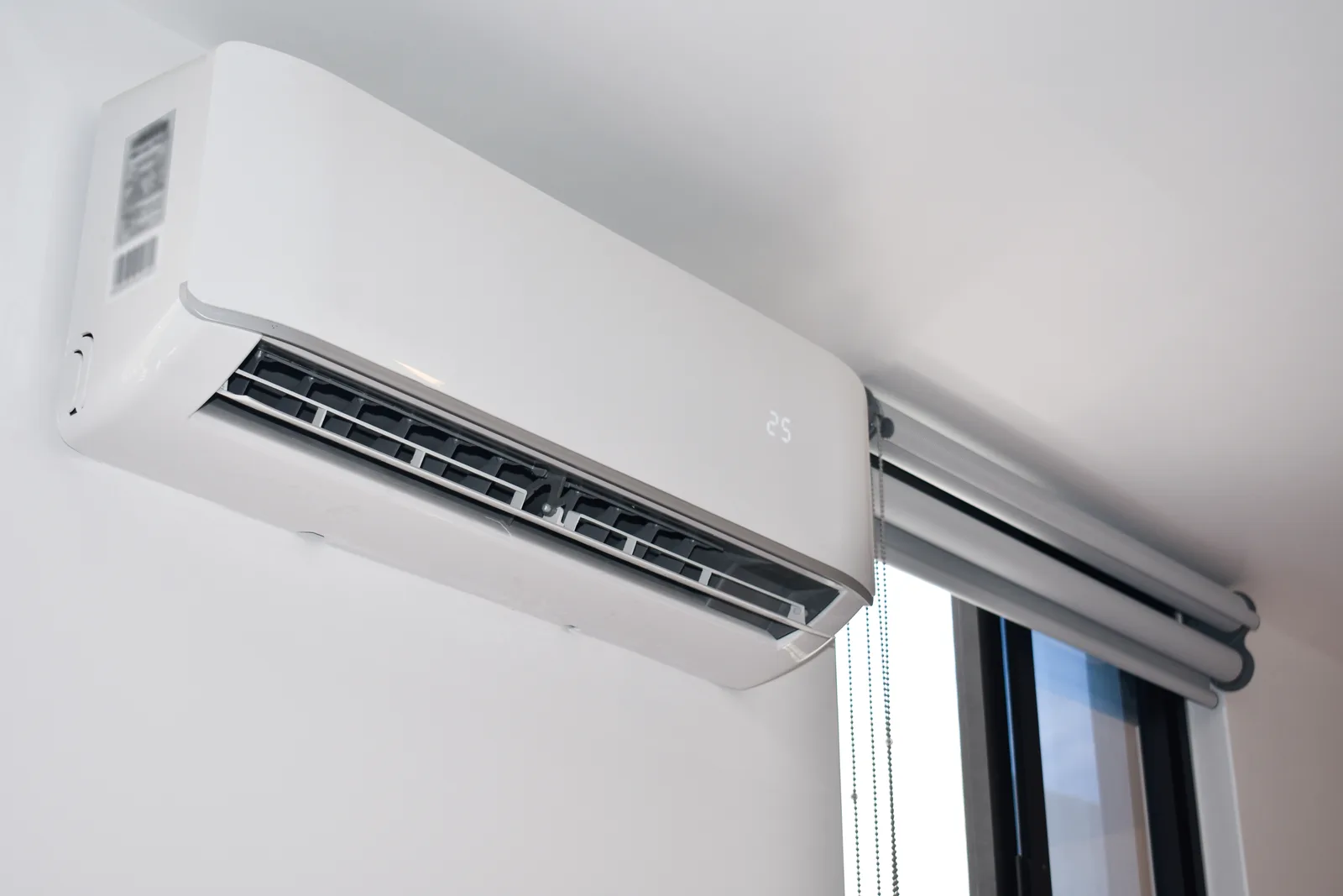 Ductless mini-split air handler mounted high on an interior wall