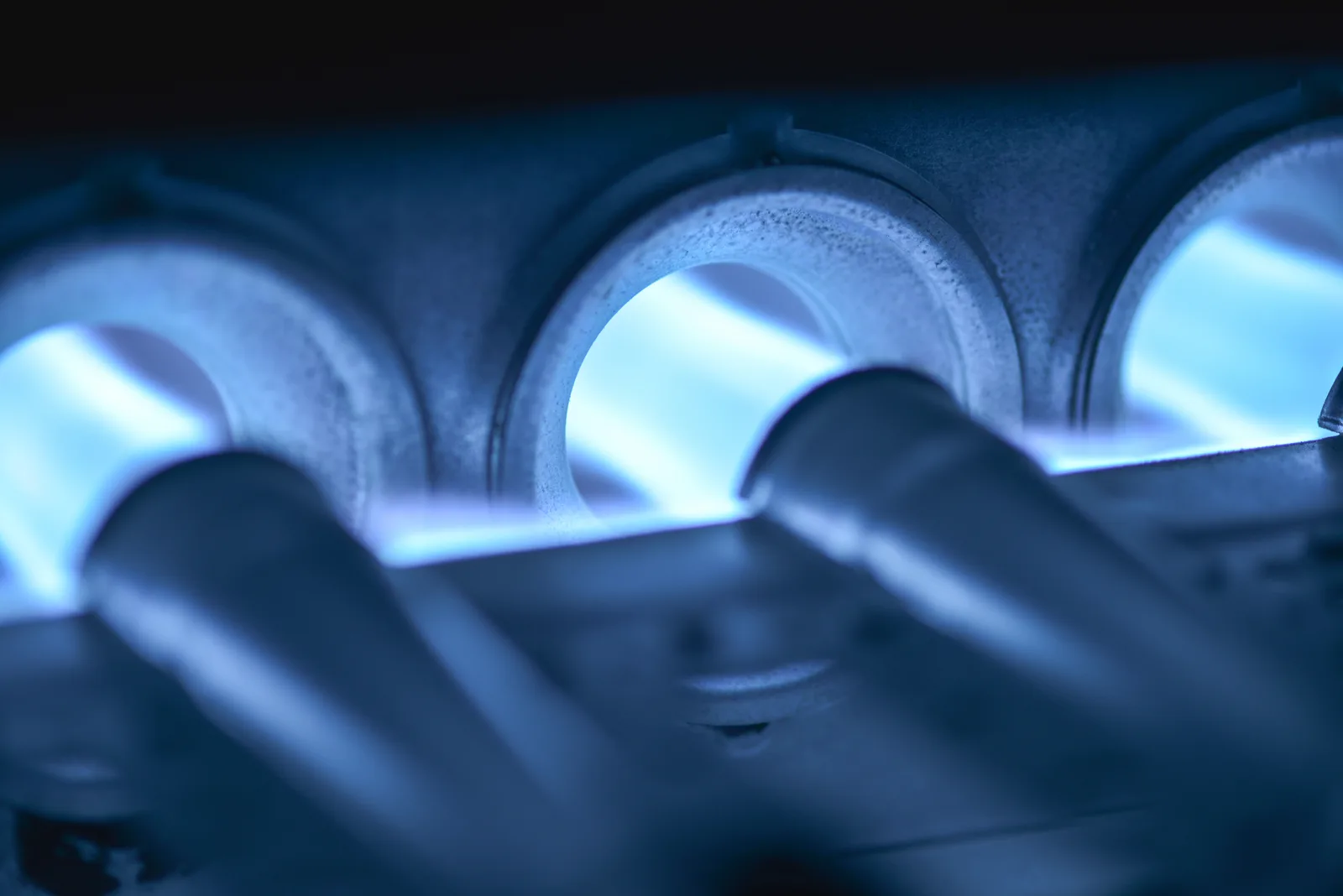 Blue gas burner flames inside a furnace during a heating inspection