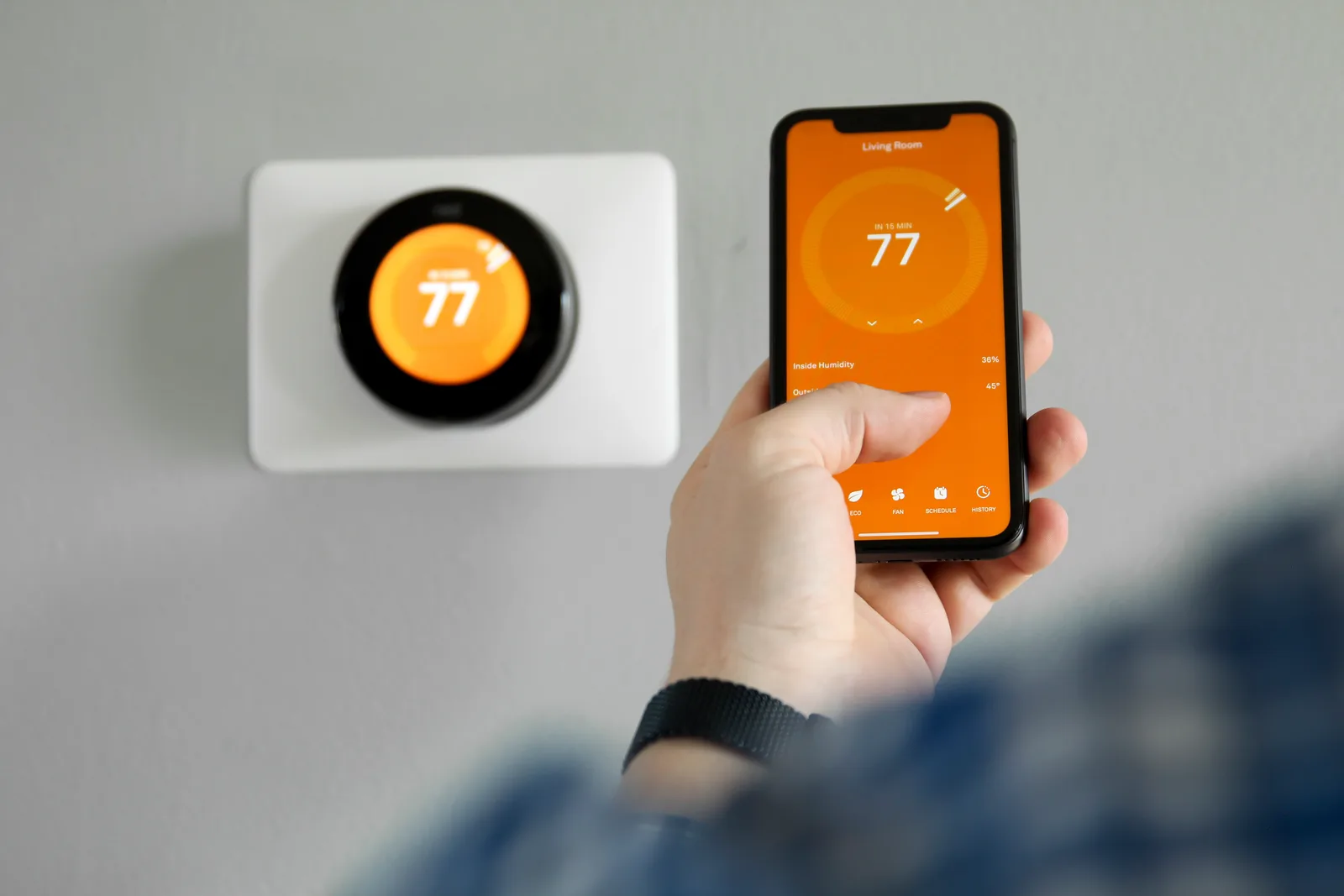 Smart Wi-Fi thermostat controlled from a phone app inside a home