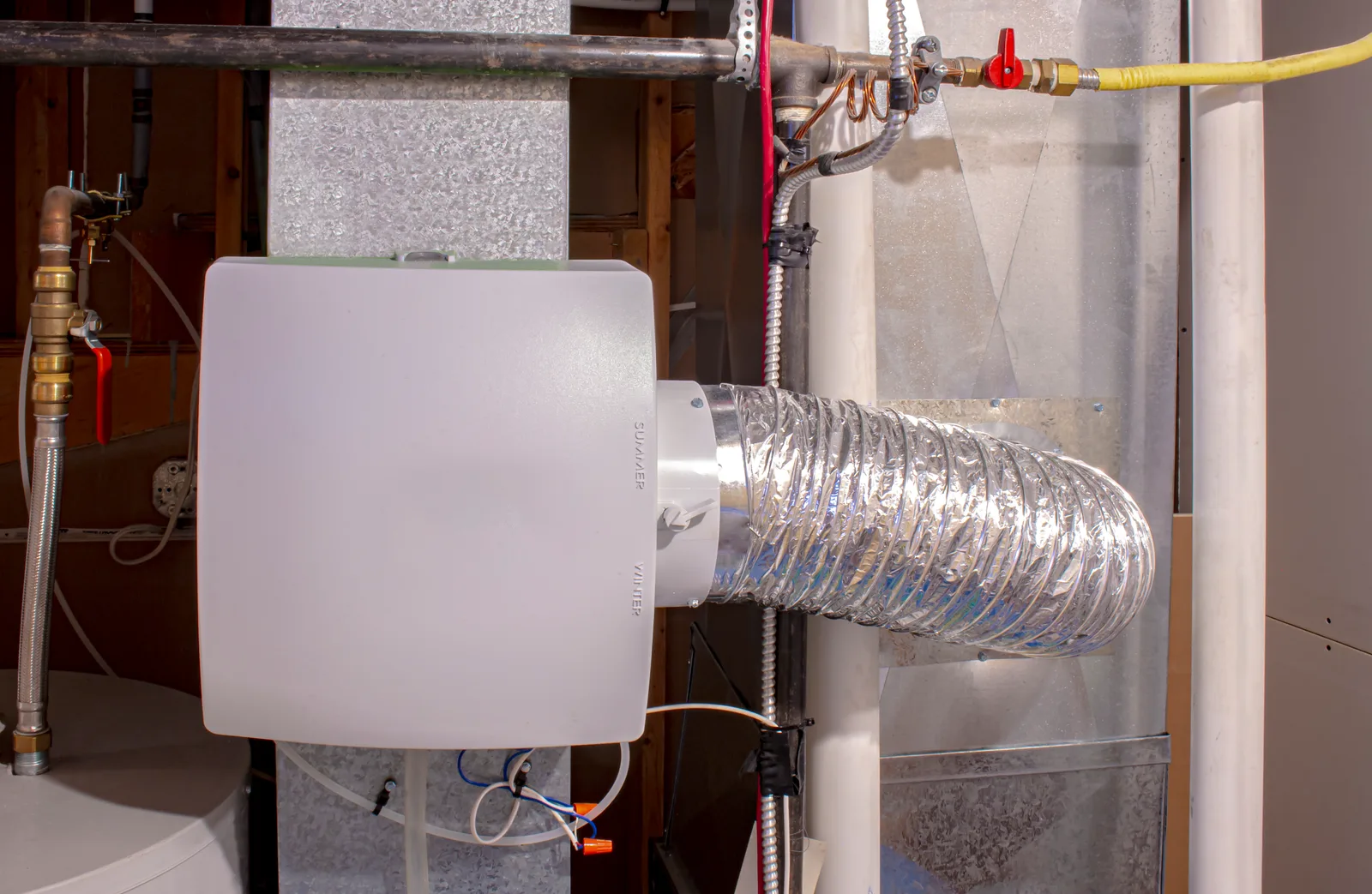 Whole-home humidifier installed on a furnace plenum with flexible ductwork