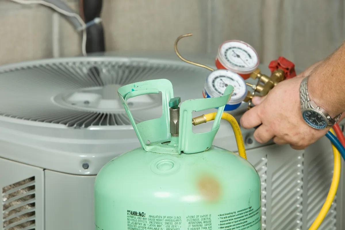 Air conditioner repair with gauges connected, preparing to charge the system