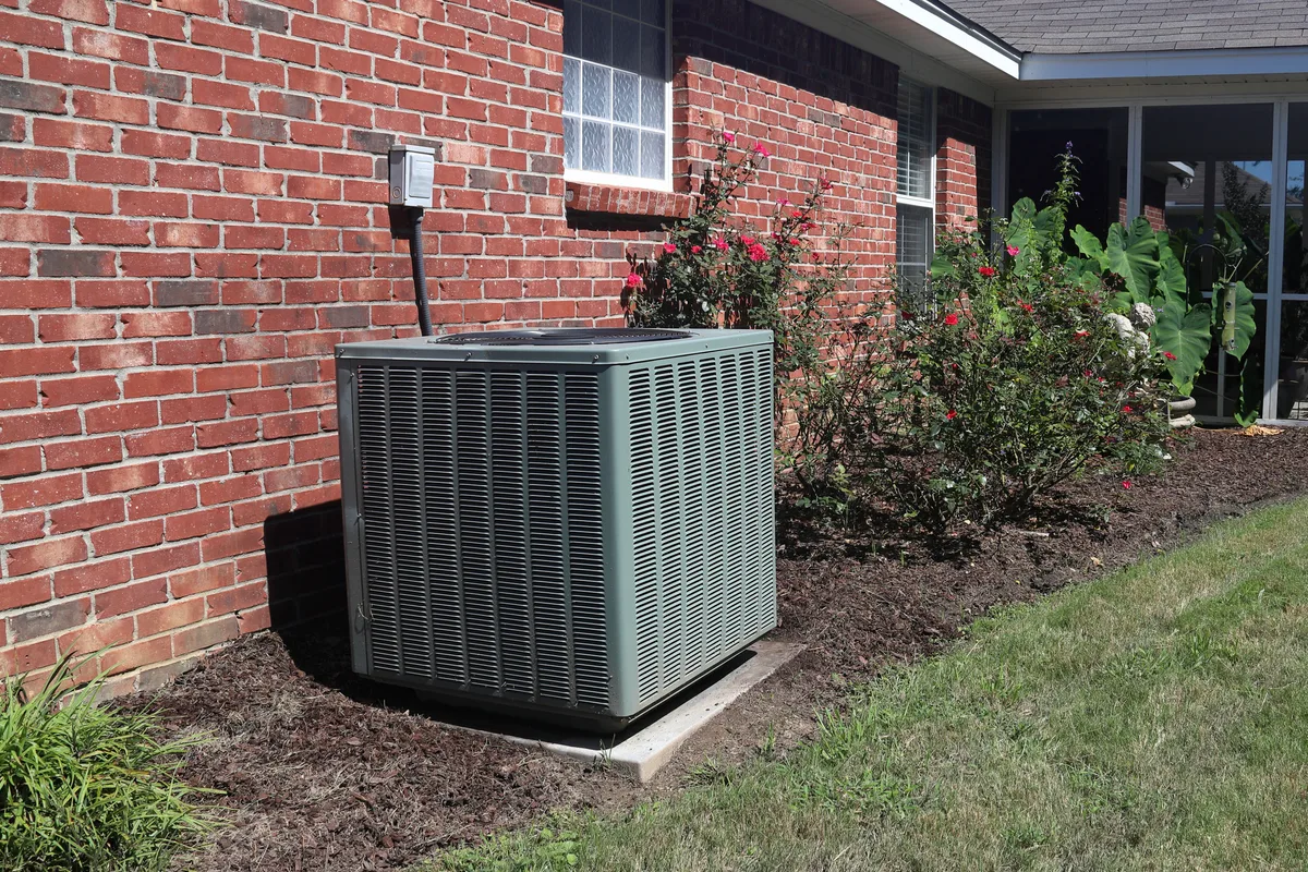 Home HVAC condenser unit next to a modern brick house