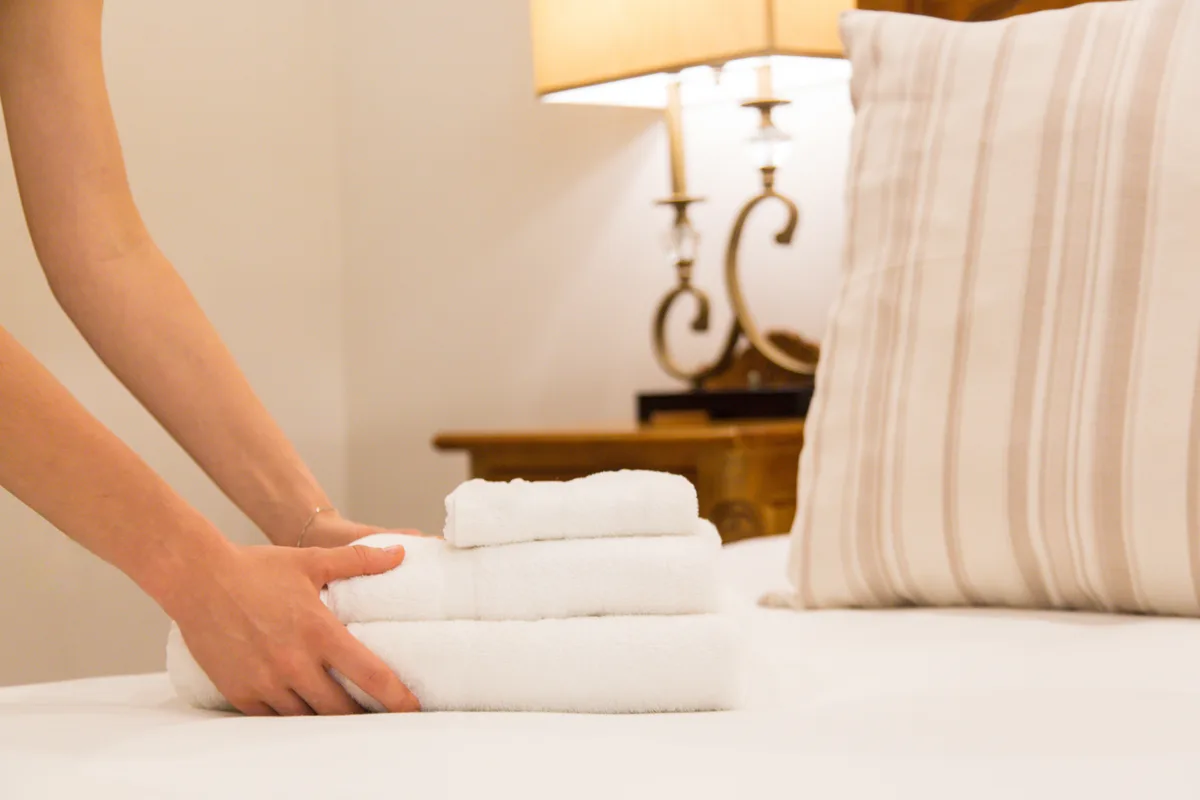 Housekeeper changing towels in a hotel room