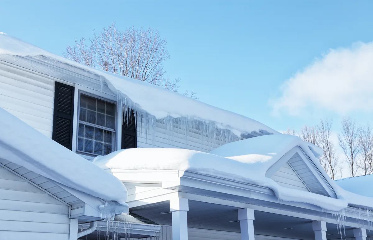 Melting snow and icicles on a residential roof edge