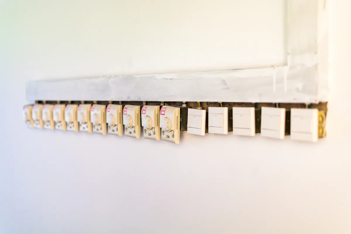 Traditional thermostats lined up on a wall