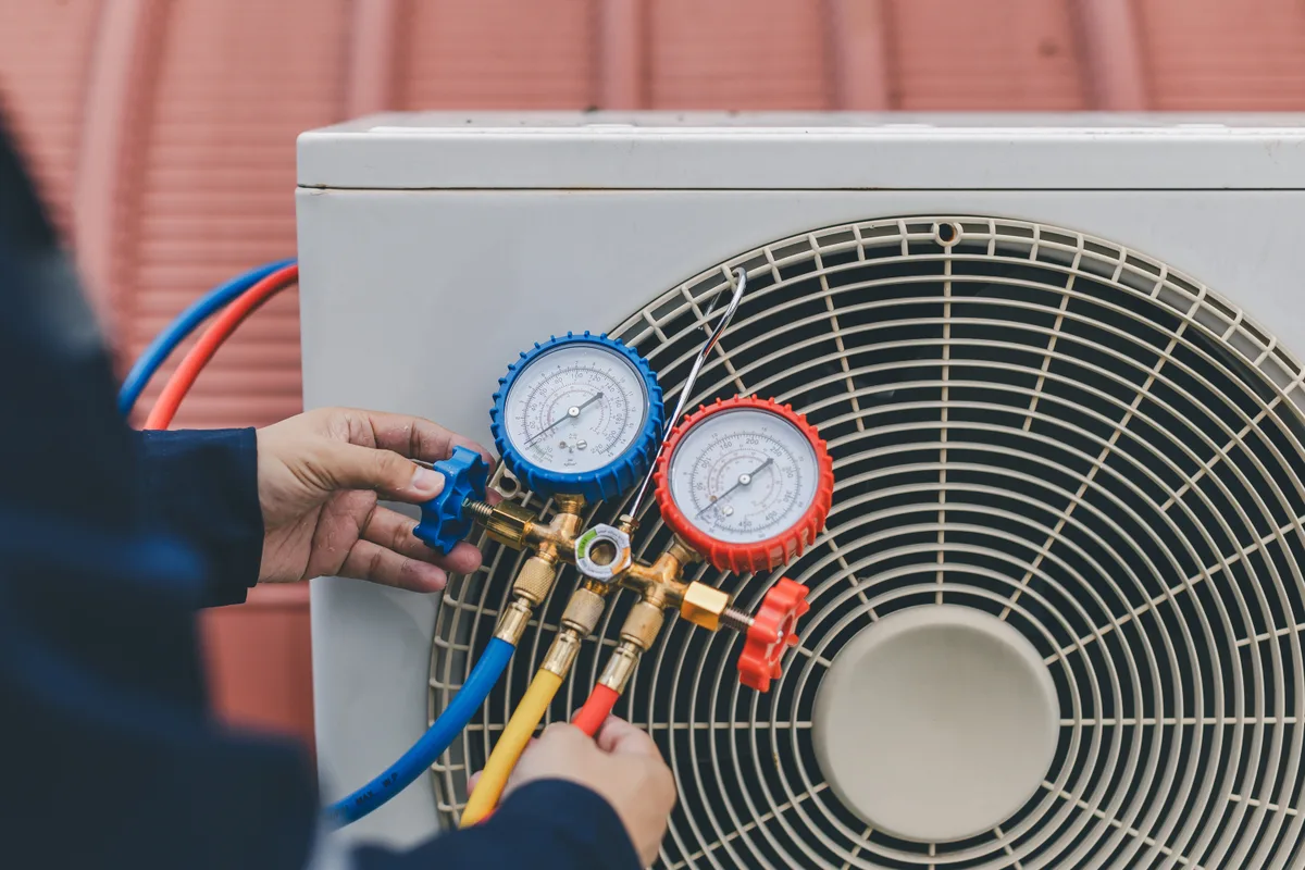 Technician checking an air conditioner with gauges