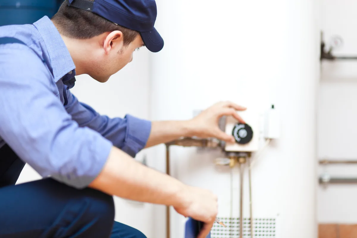 Technician repairing a tank water heater